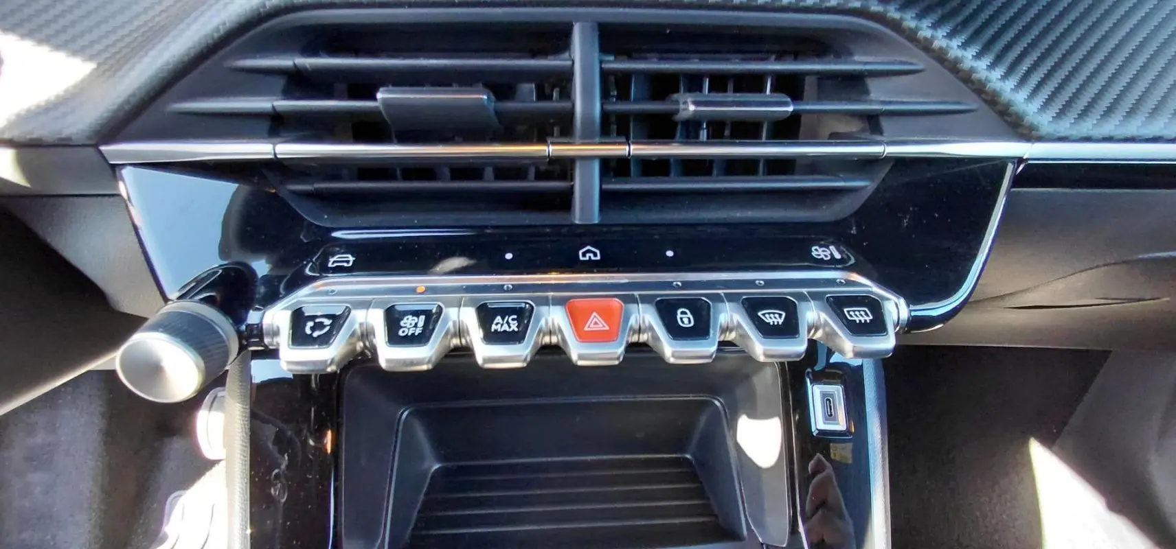 Gros plan sur la console centrale du Peugeot 2008 Hybrid 136 e-DCS6 Style 2025 avec boutons chromés et écran tactile.