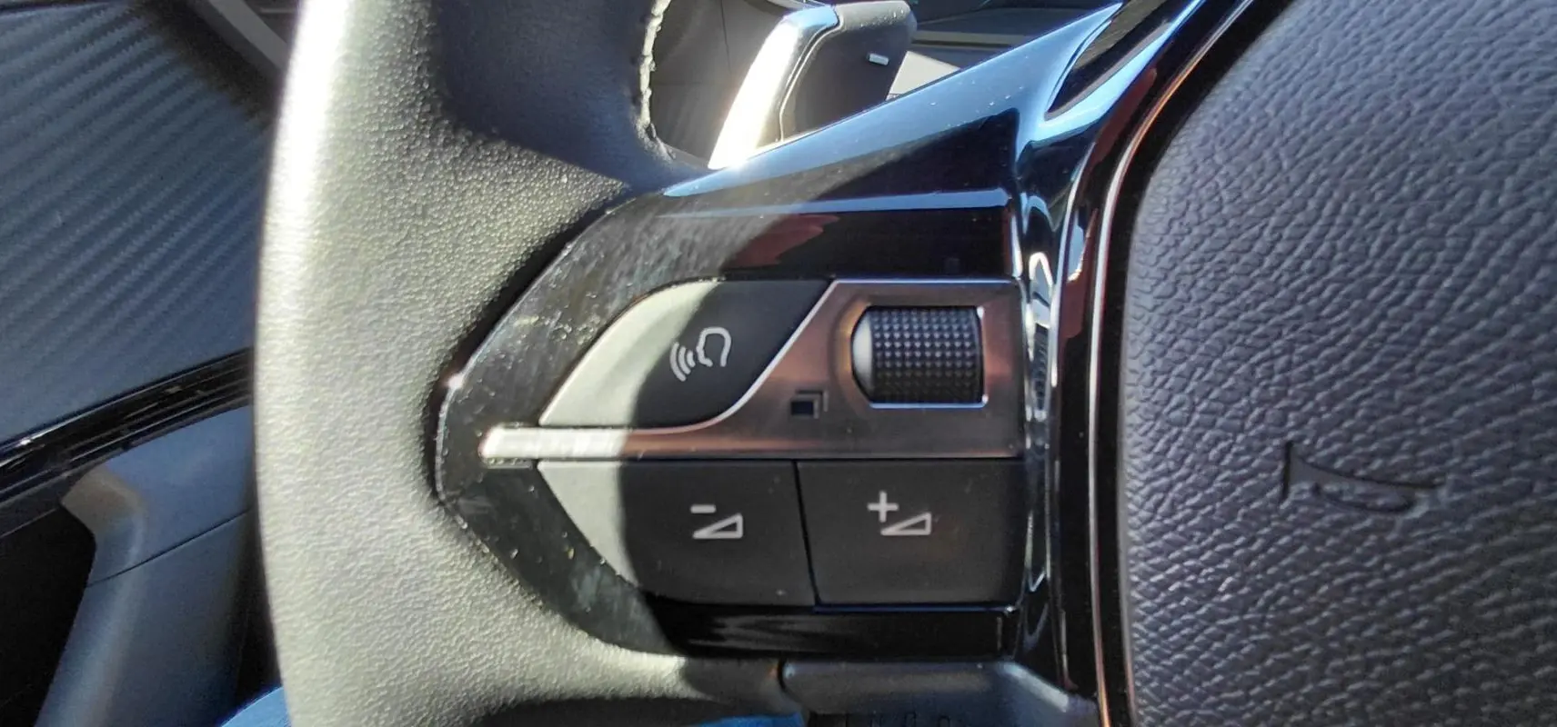 Gros plan sur les commandes vocales et volume au volant du Peugeot 2008 Hybrid 136 e-DCS6 Style 2025.