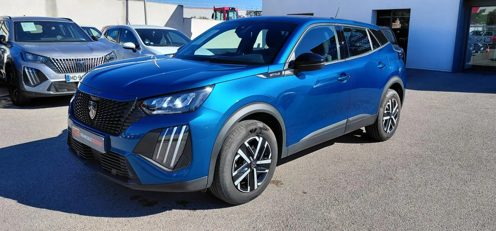 Peugeot 2008 Hybrid bleu en 3/4 avant droit, avec jantes 16 pouces et signature lumineuse verticale distinctive.