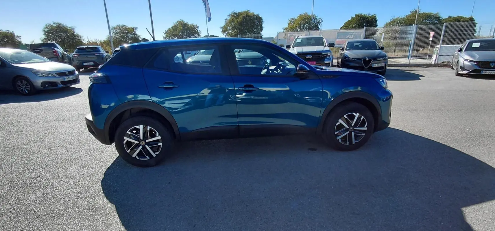 Peugeot 2008 Hybrid bleu en vue profil côté gauche, avec jantes 16 pouces et détails noirs contrastants.