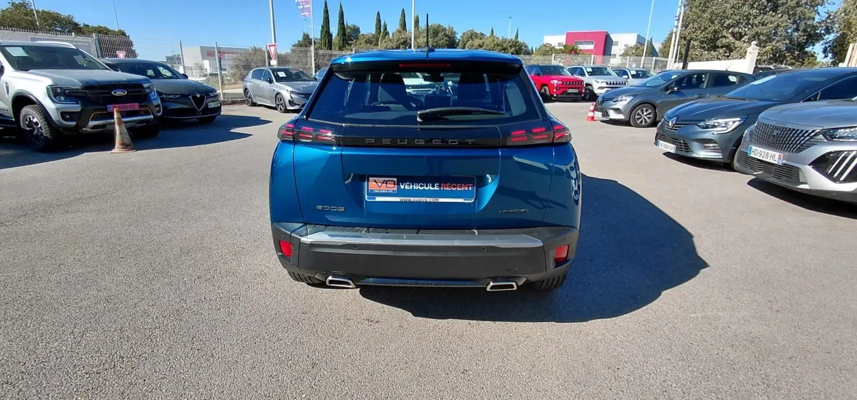 Vue arrière d'un Peugeot 2008 Hybrid bleu 2025 avec feux LED et double sortie d'échappement chromée.