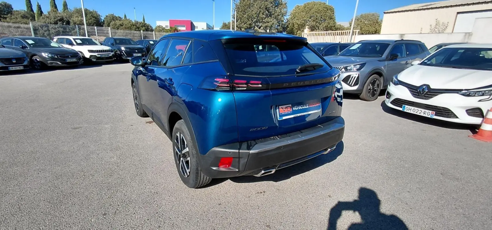 Peugeot 2008 Hybrid bleu en 3/4 arrière droit, avec jantes 16 pouces et feux arrière distinctifs.