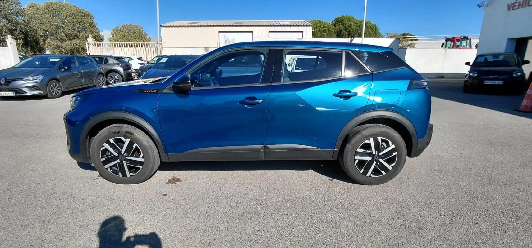 Profil côté gauche du Peugeot 2008 Hybrid 136 e-DCS6 Style bleu 2025 avec jantes 16 pouces et détails noirs contrastants.