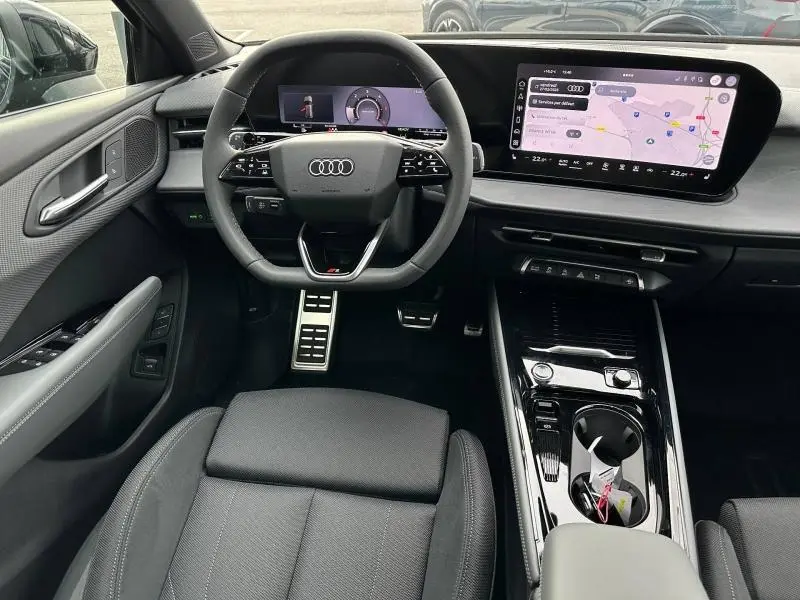 Vue intérieure avant de l'Audi Q3 2.0 TDI 150ch S line 2026, avec volant cuir multifonction et écran tactile GPS.