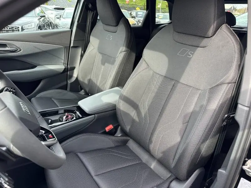 Vue intérieure côté avant droit de l’Audi Q3 2.0 TDI S line 2026 avec sièges sport noirs et logo S brodé.