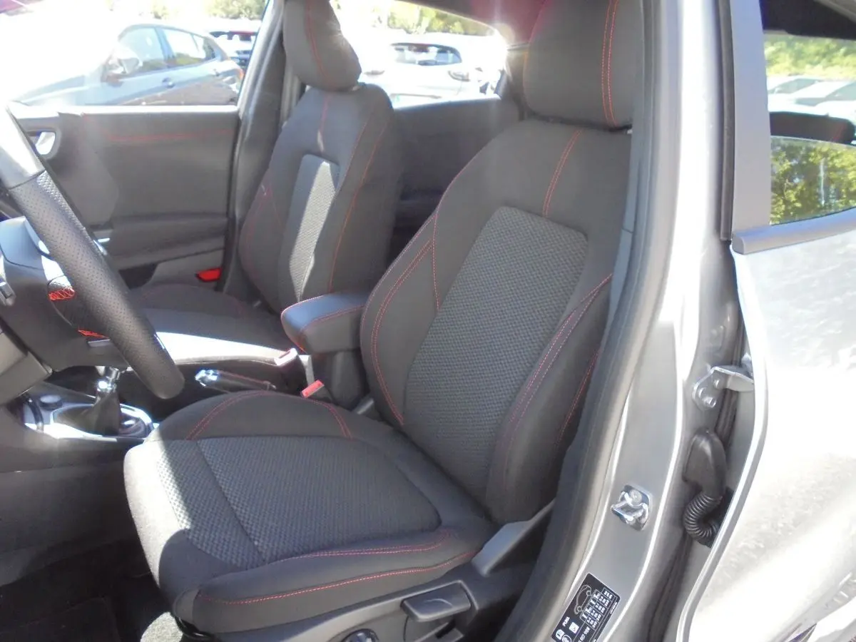 Intérieur avant droit du Ford Puma gris Solar Metal 2022, sièges tissu noir avec surpiqûres rouges visibles.