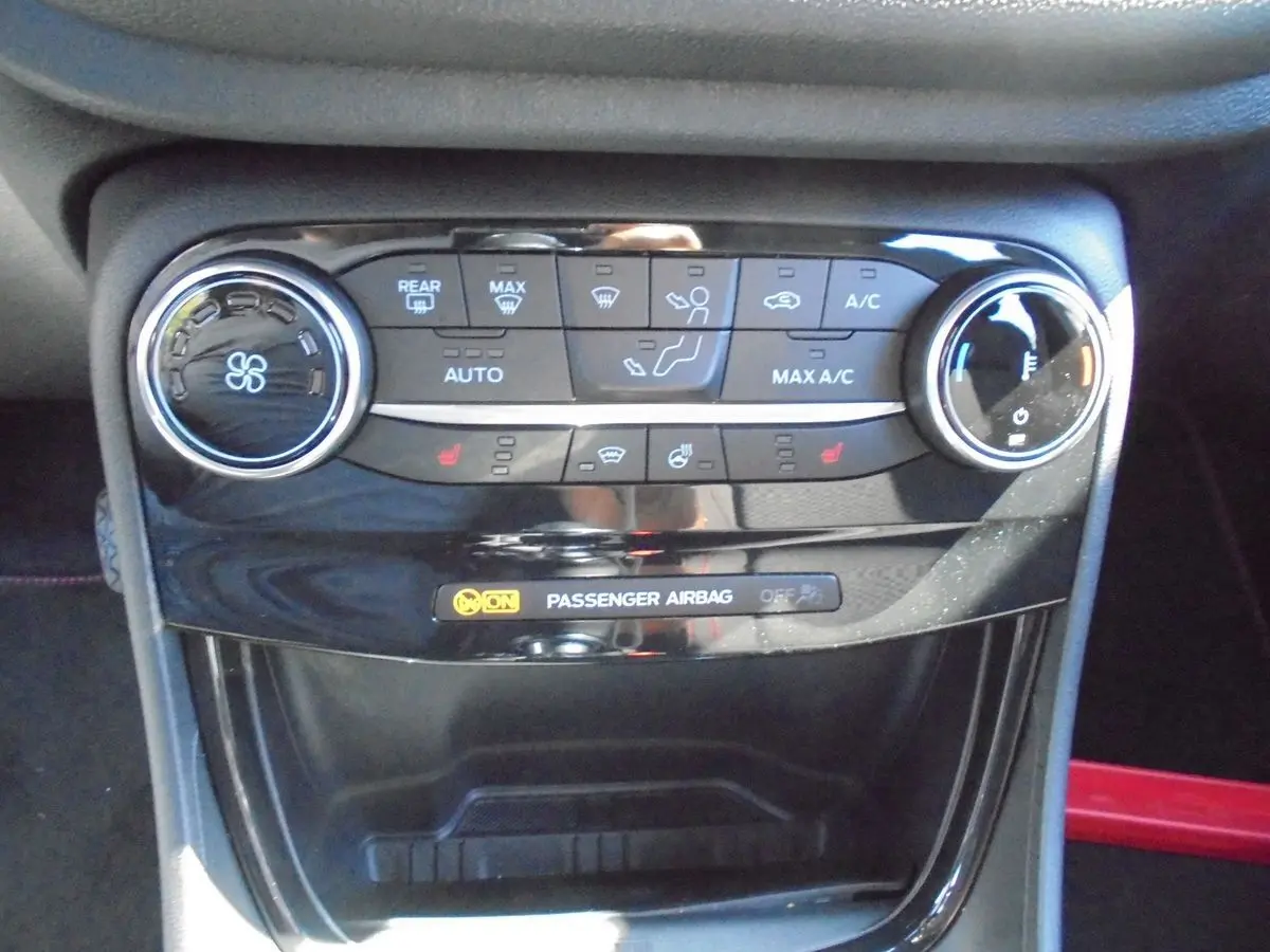 Gros plan sur la console centrale du Ford Puma 2022, mettant en valeur les commandes de climatisation et l'indicateur d'airbag passager.