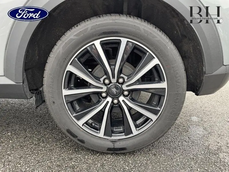 Gros plan sur la jante alu 17 pouces Absolute Black du Ford Puma gris Solar métallisé côté gauche arrière.