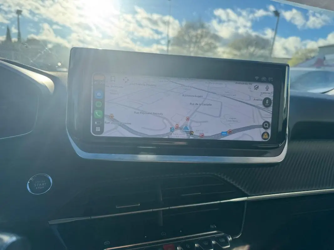 Écran tactile du système de navigation du Peugeot 2008 Hybrid 136 Allure, vue intérieure avant avec lumière naturelle.