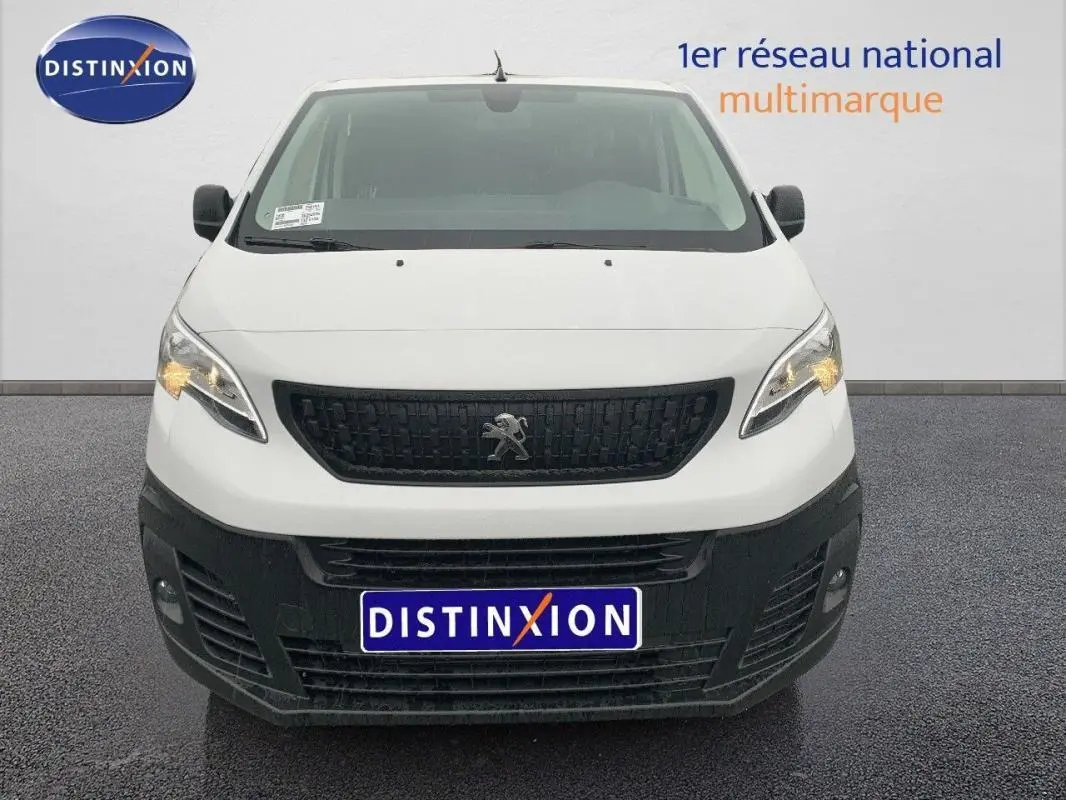 Vue avant d’un Peugeot Expert Fourgon blanc 2023 avec calandre noire et feux allumés sur fond neutre.