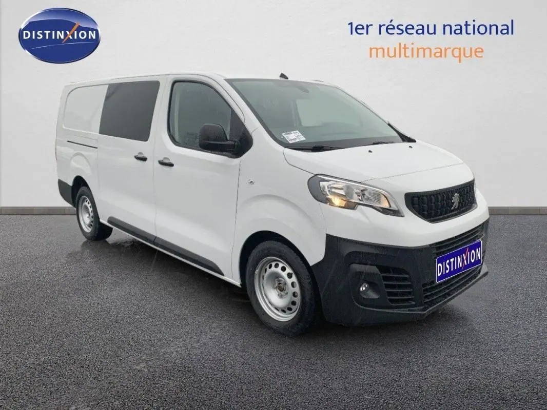 Peugeot Expert Fourgon blanc en 3/4 avant droit, avec calandre noire et feux allumés sur sol gris.