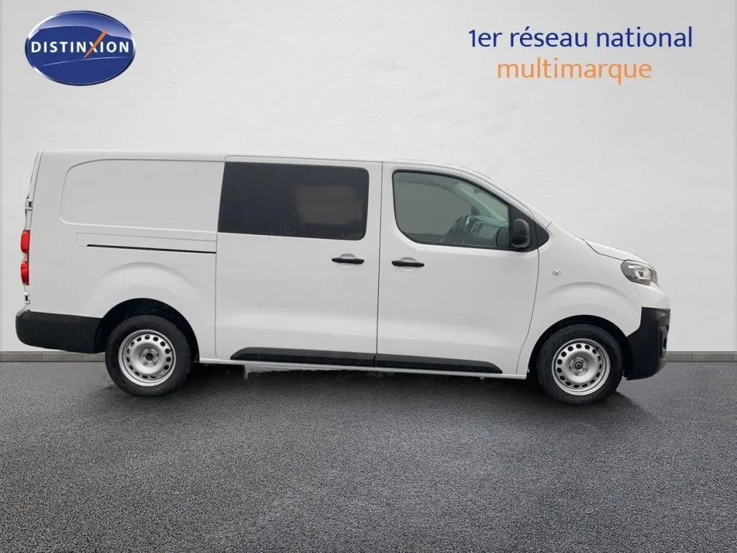 Vue de profil côté gauche d’un Peugeot Expert Fourgon blanc 2023 avec cabine approfondie et vitres teintées arrière.