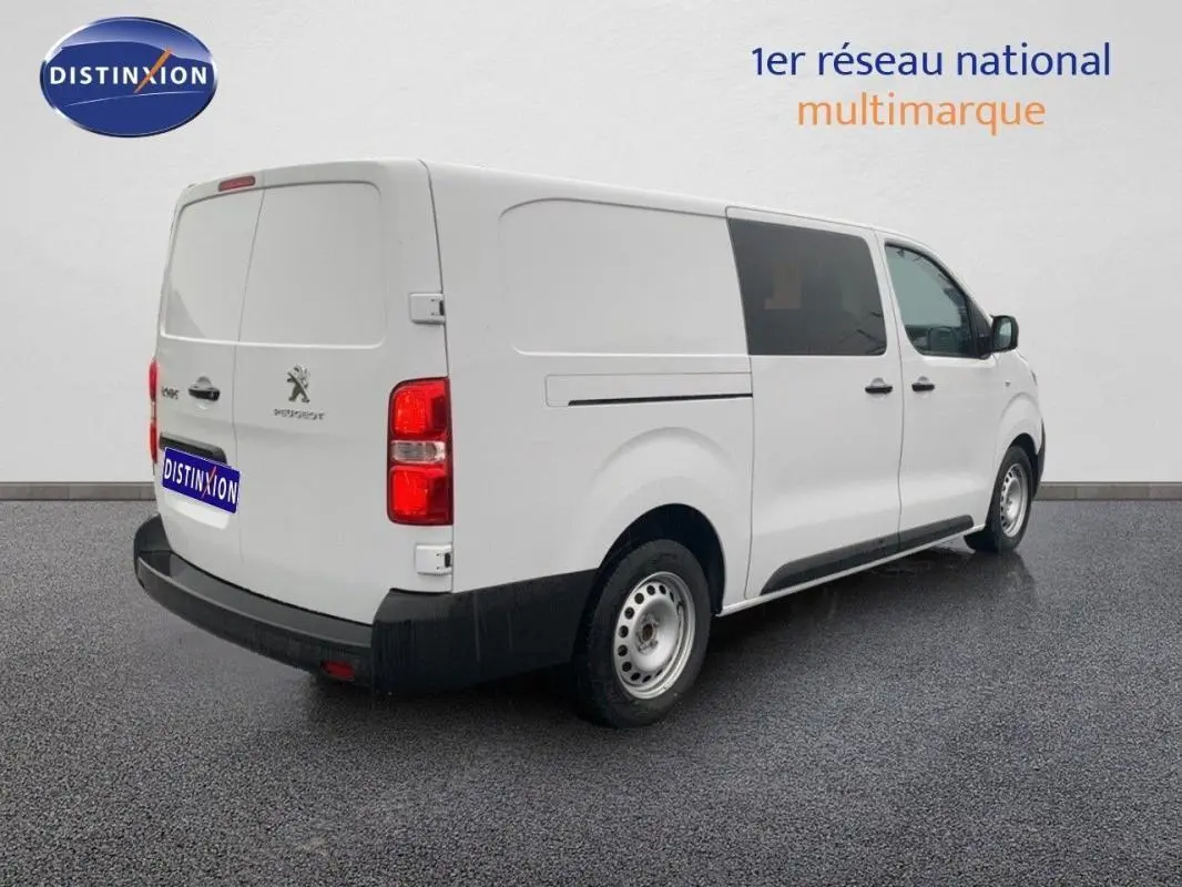 Vue 3/4 arrière droite d’un Peugeot Expert Fourgon blanc, avec portes latérales et arrière fermées, sur sol gris.