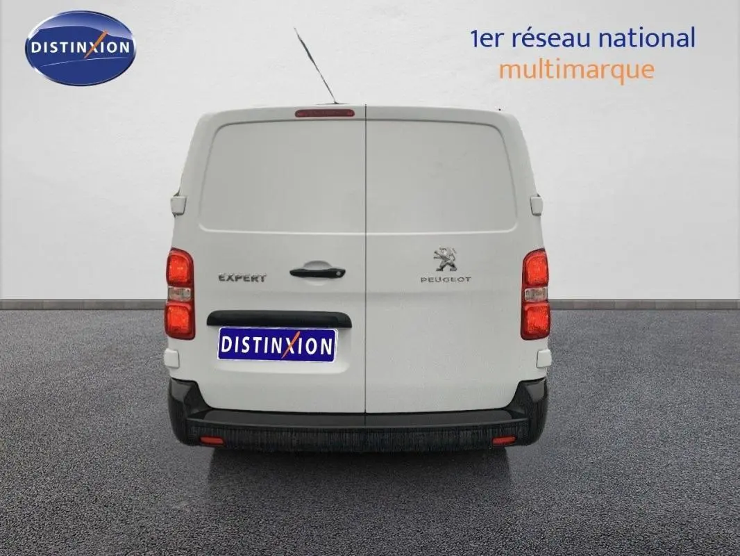 Vue arrière d’un Peugeot Expert Fourgon blanc 2023 avec portes battantes fermées et feux rouges visibles.