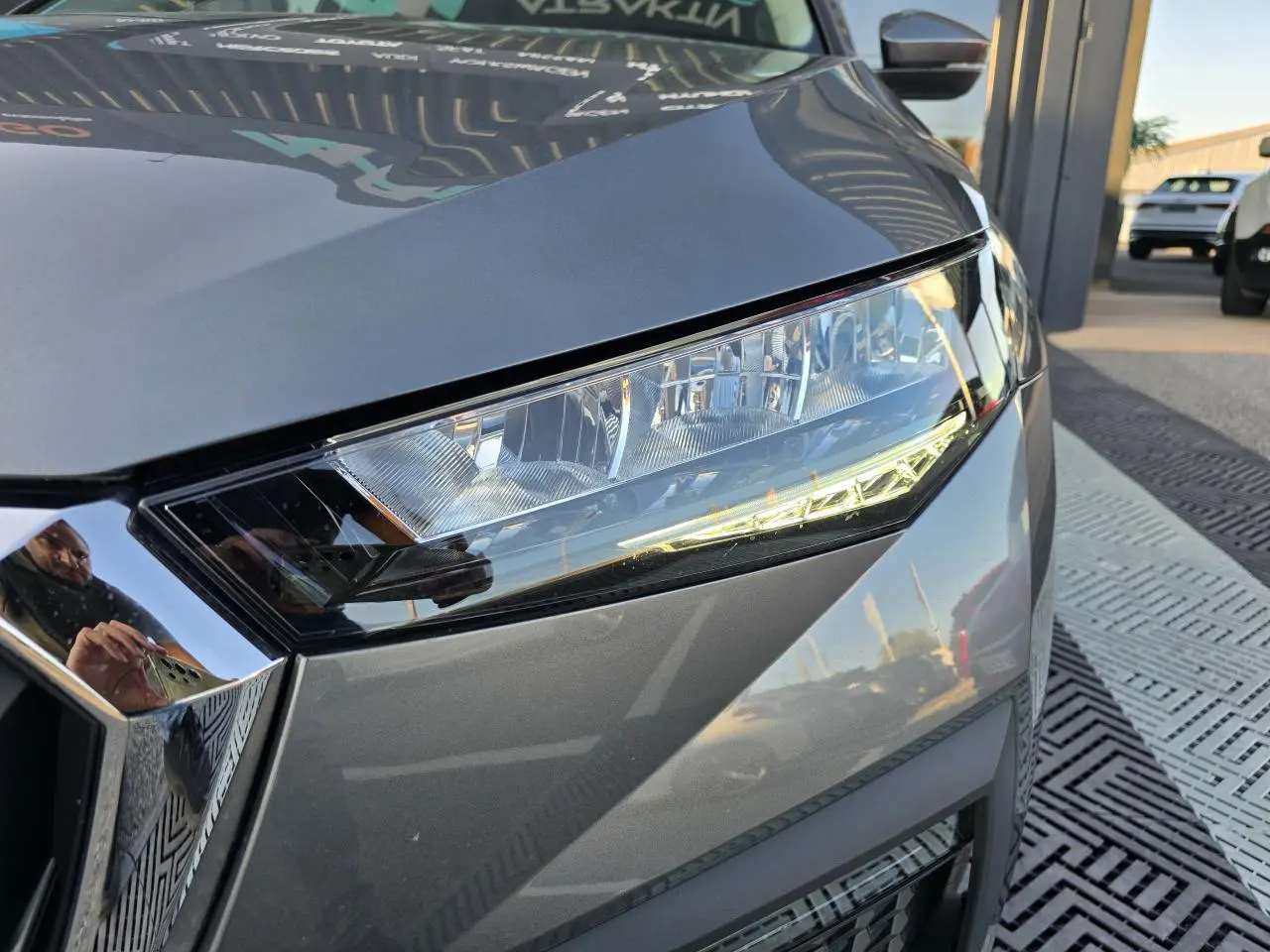 Gros plan sur le phare avant droit d’une Skoda Scala 2024 gris graphite métallisé avec calandre chromée.