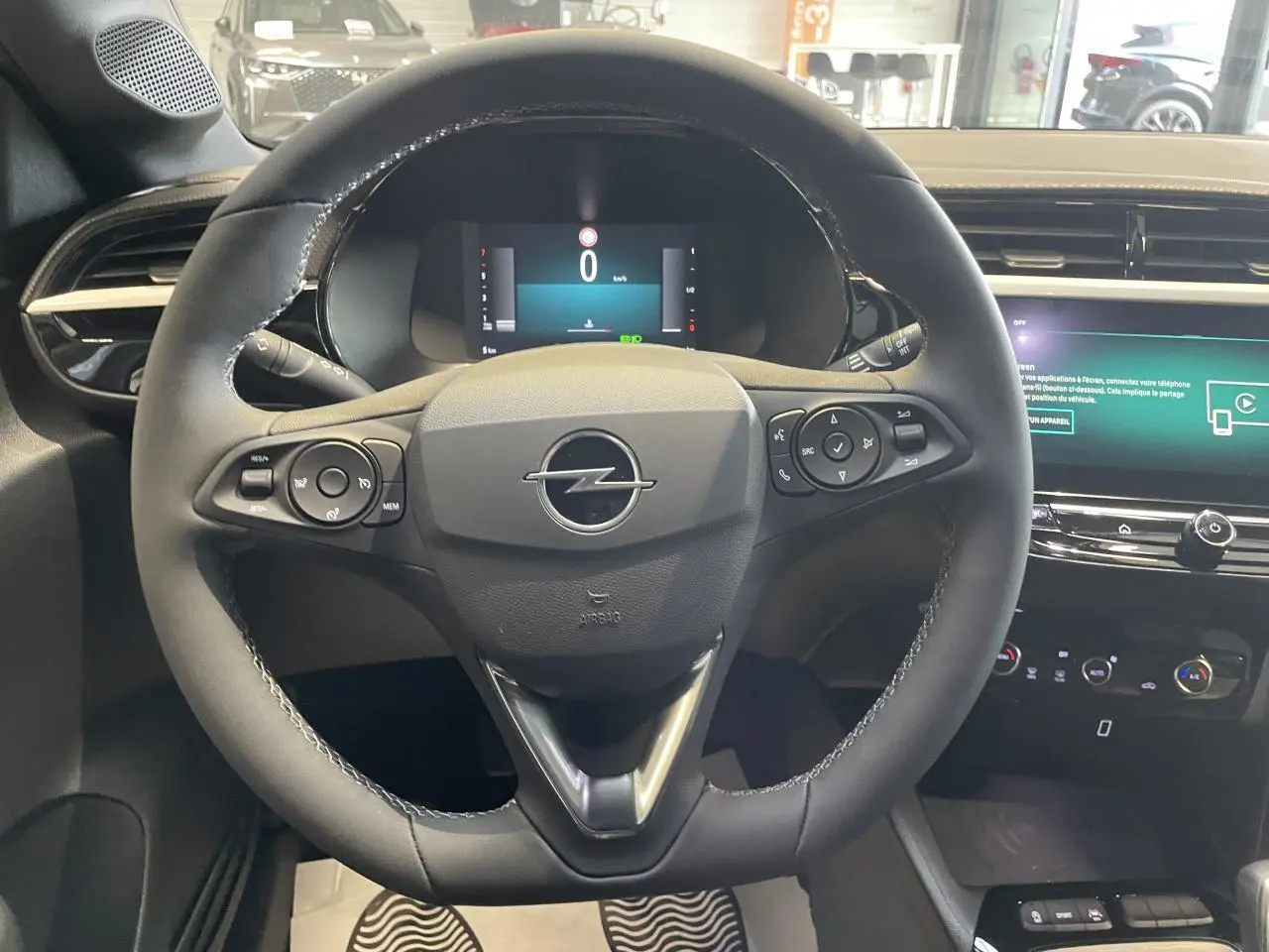 Vue frontale du volant en cuir noir de l'Opel Corsa 2026 avec tableau de bord numérique et écran tactile multimédia.