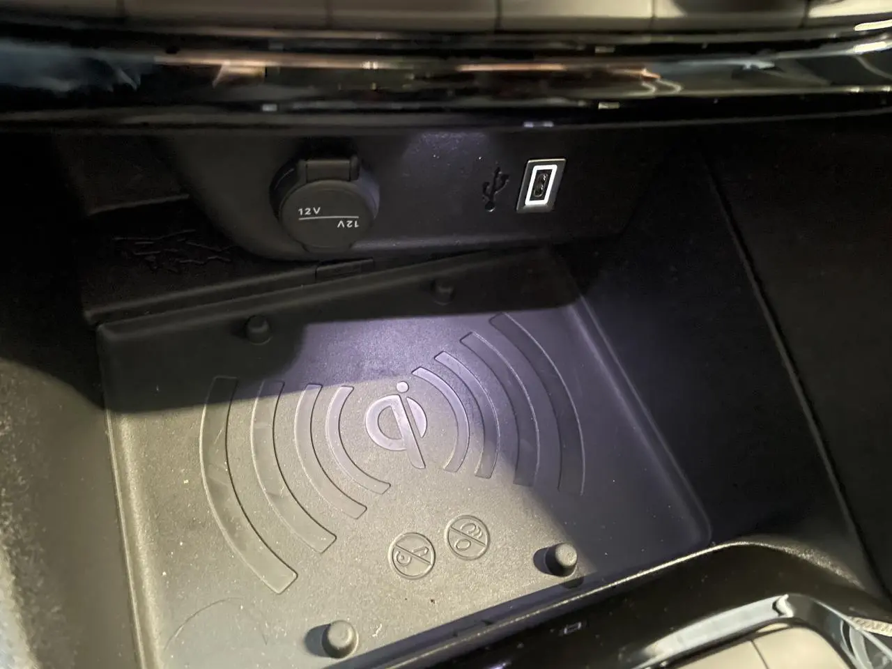 Gros plan sur le chargeur à induction et prise USB dans la console centrale d'une Opel Corsa blanche.