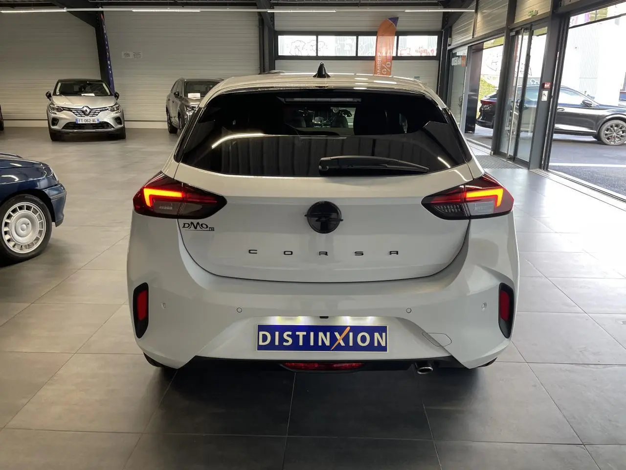 Vue arrière d'une Opel Corsa blanche 2026 avec feux LED allumés dans un showroom.