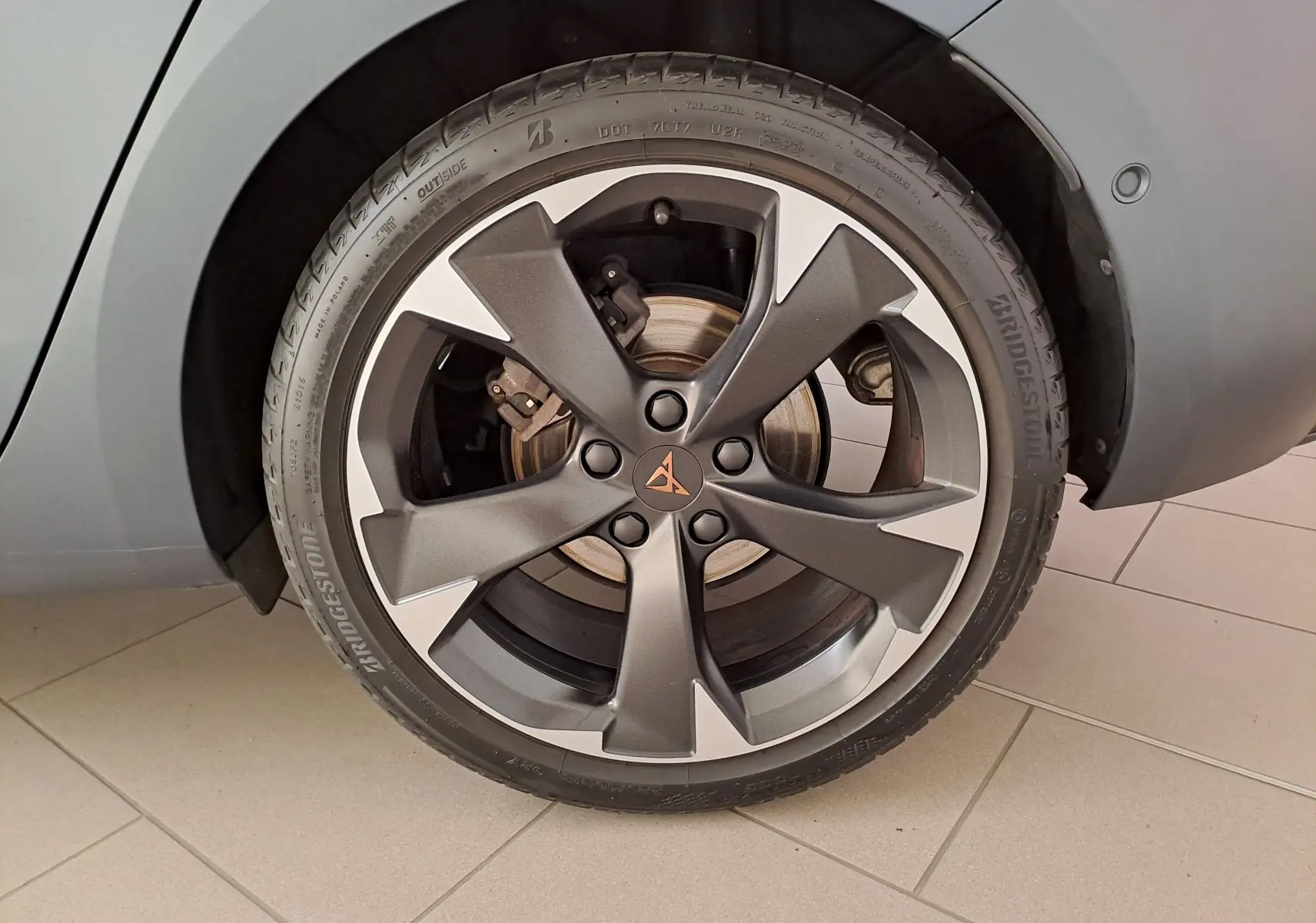 Gros plan sur la roue avant droite de la CUPRA Leon 2024 gris magnétique mat avec jante alliage au design moderne.