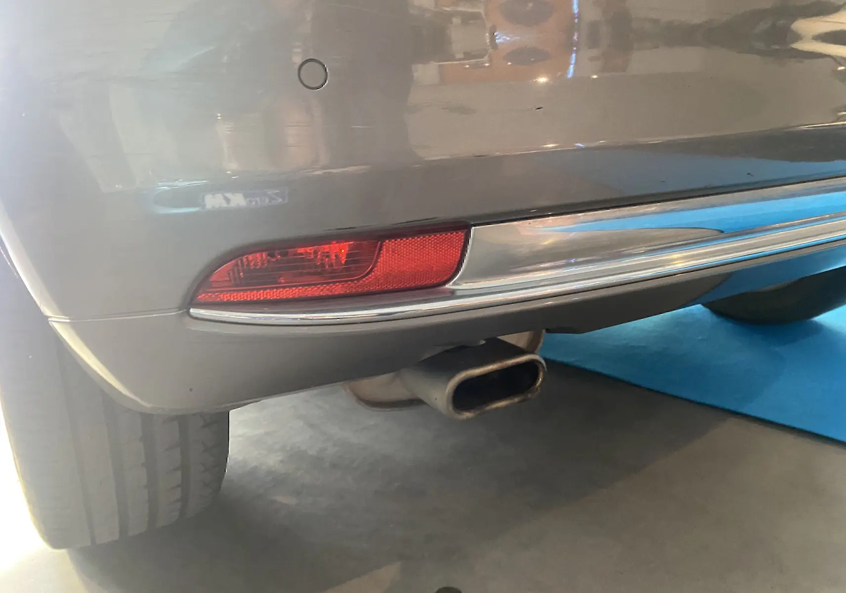 Gros plan sur le feu arrière droit et l’échappement d’une FIAT 500 gris foncé, vue arrière basse.