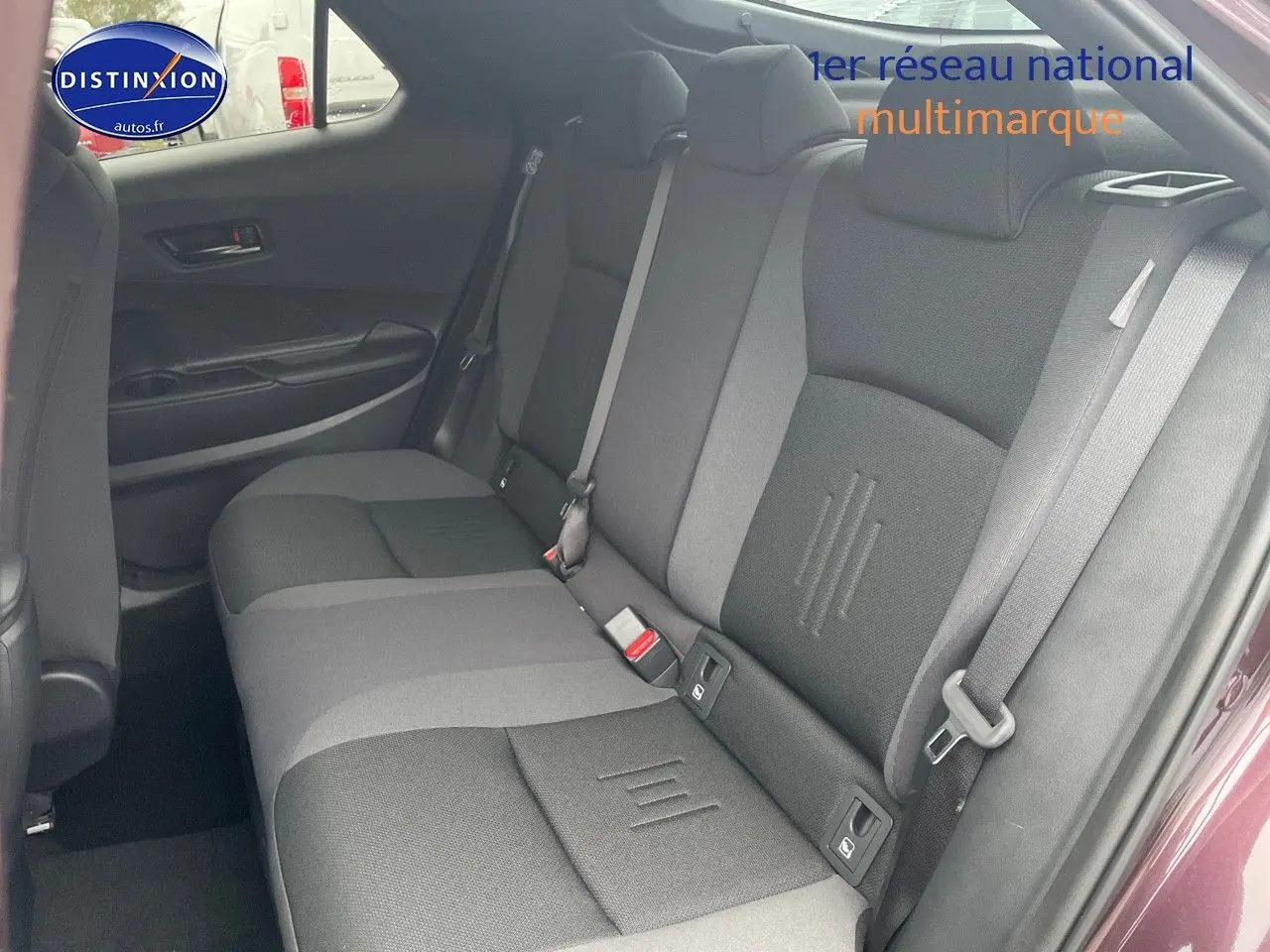 Vue intérieure côté droit montrant la banquette arrière grise et noire du Toyota C-HR 1.8 Hybrid 2024 couleur Améthyste Metal.