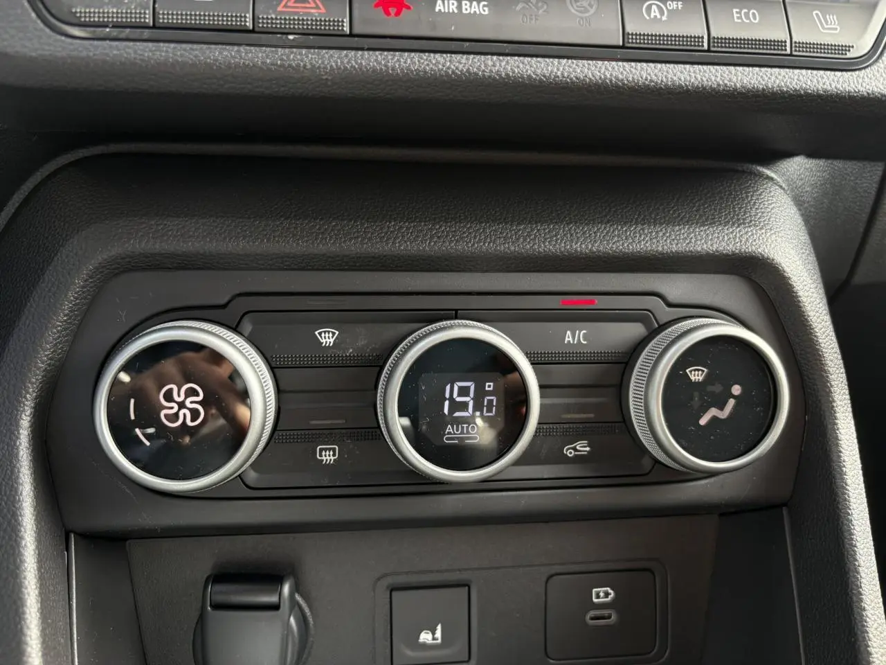 Gros plan sur les commandes de climatisation automatique du Dacia Jogger 2024, affichant 19°C et réglages ventilateur.