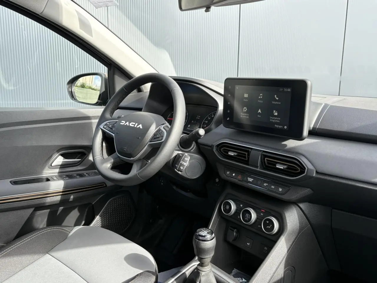Intérieur du Dacia Jogger 2024, vue côté conducteur, volant multifonction et écran tactile 8 pouces au tableau de bord.