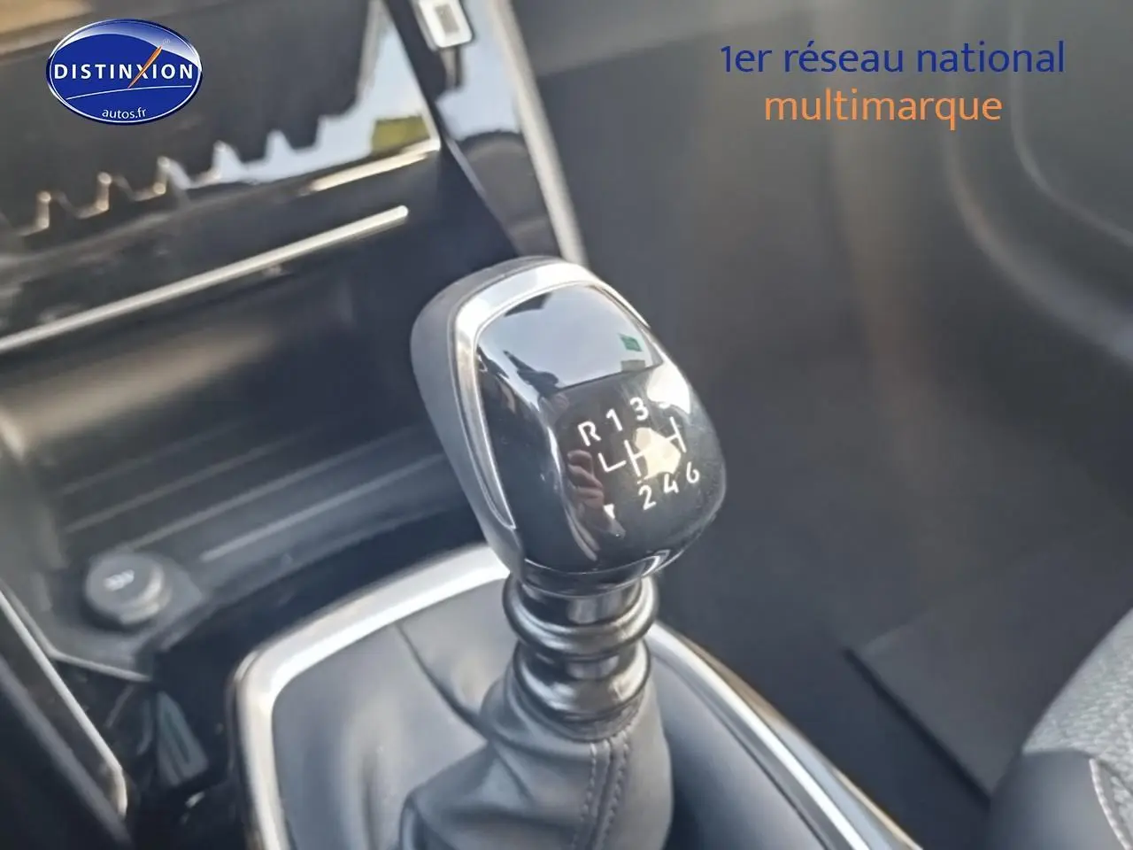 Gros plan sur le levier de vitesses manuel noir dans l'habitacle d'une Peugeot 208 gris artense.