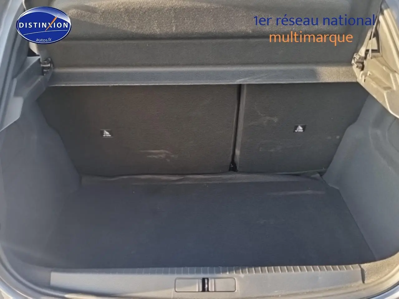 Coffre ouvert d’une Peugeot 208 gris artense, montrant l’espace de chargement arrière vide.