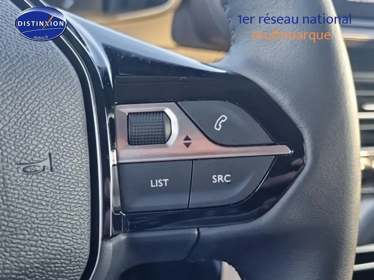 Gros plan sur les commandes audio au volant d’une Peugeot 208 gris Artense, version 1.2 100 allure 2025.