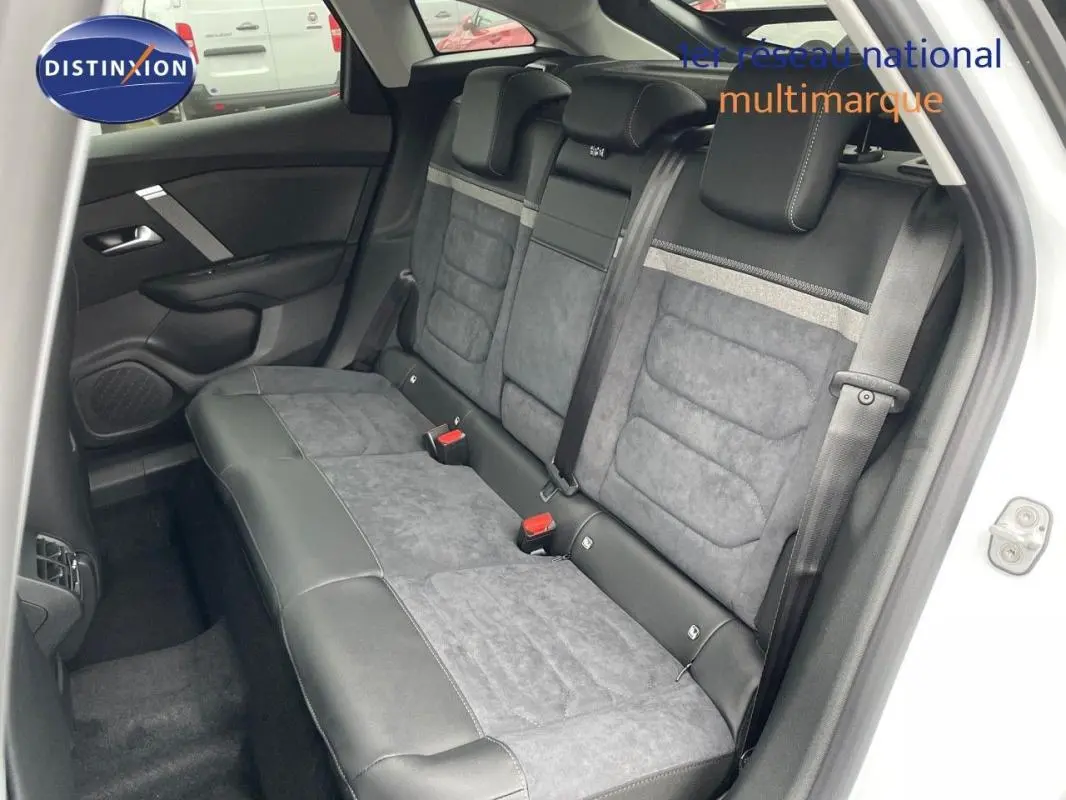 Vue intérieure côté arrière droit montrant les sièges arrière en cuir et tissu gris d'une Citroën C4 blanche 2024.