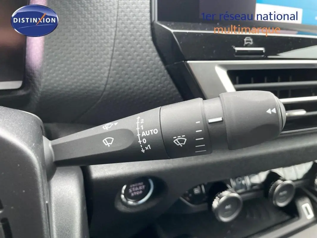 Gros plan sur la commande des essuie-glaces dans l’habitacle de la Citroën C4 blanche 2024, côté gauche du volant.