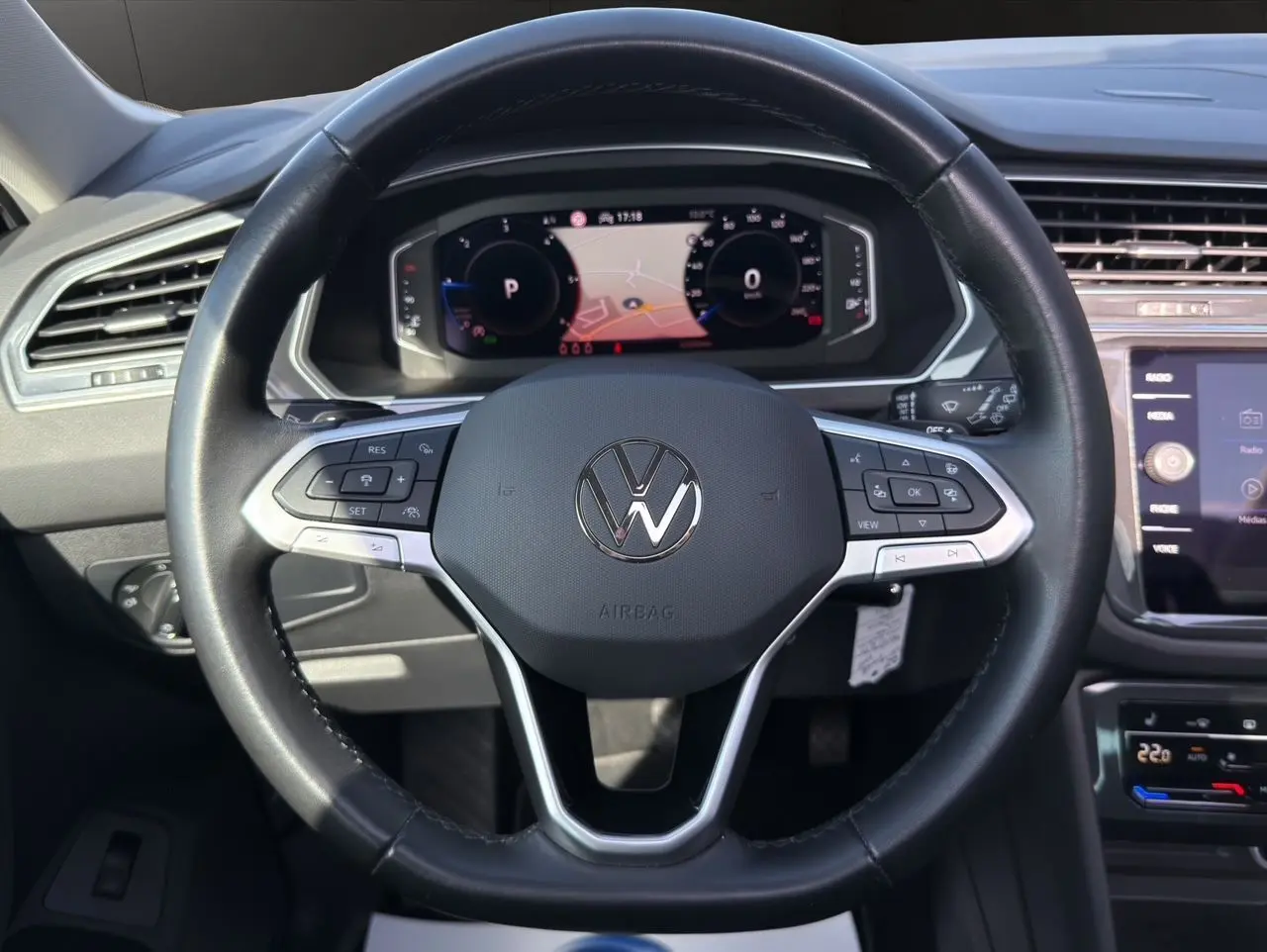 Vue rapprochée du volant cuir multifonction noir avec tableau de bord numérique et écran tactile du Volkswagen Tiguan 2022.