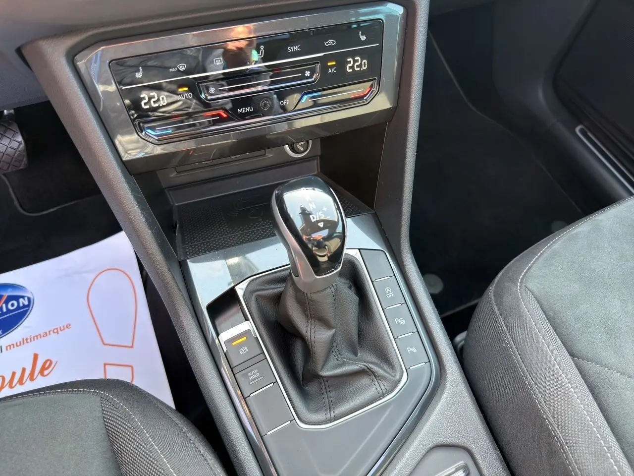 Vue rapprochée de la console centrale du Volkswagen Tiguan 2.0 TDI 150 DSG7 avec levier de vitesses et commandes climatisation digitale.