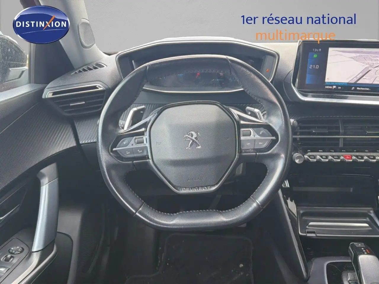 Vue intérieure centrée sur le volant noir du Peugeot 2008 avec tableau de bord numérique et écran tactile GPS.