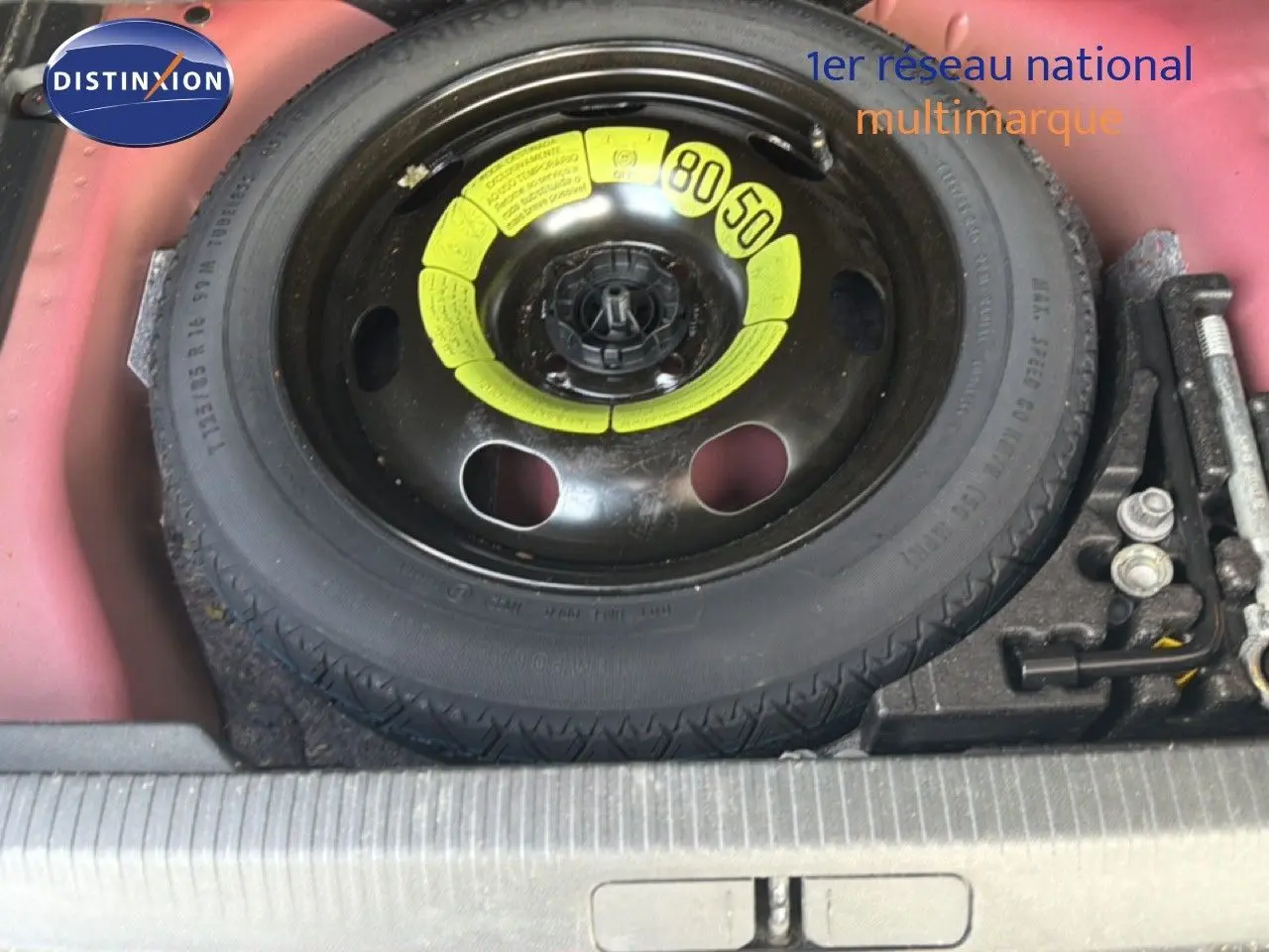 Vue rapprochée de la roue de secours noire avec marquages jaunes dans le coffre rouge du Peugeot 2008 2020 toit noir.