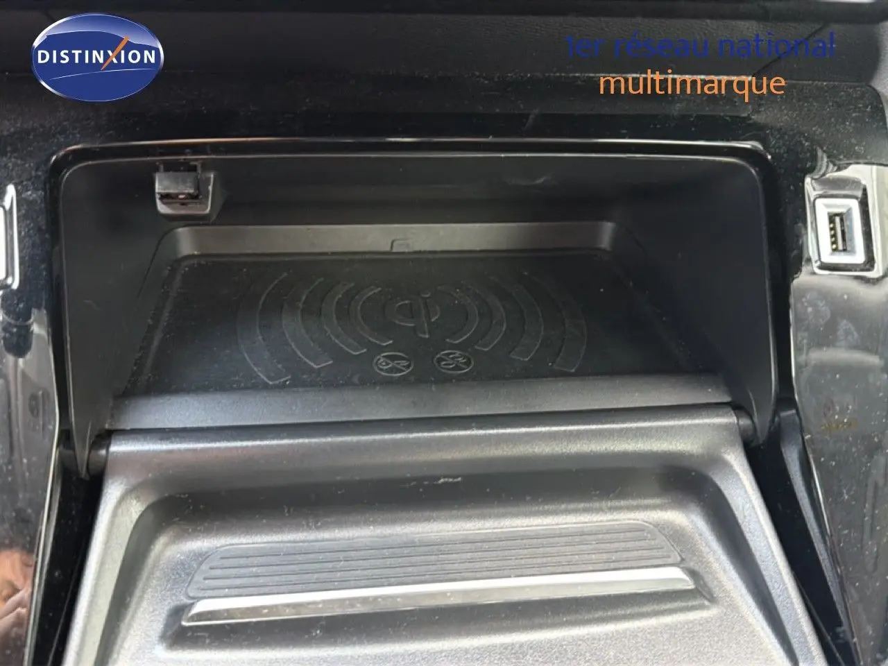 Gros plan sur la console centrale du Peugeot 2008 2020, montrant le compartiment de recharge sans fil et port USB.
