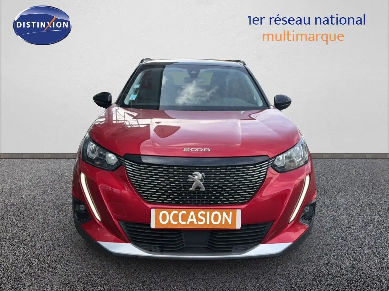 Vue avant d'un Peugeot 2008 rouge à toit noir avec calandre noire et feux LED en forme de griffes.