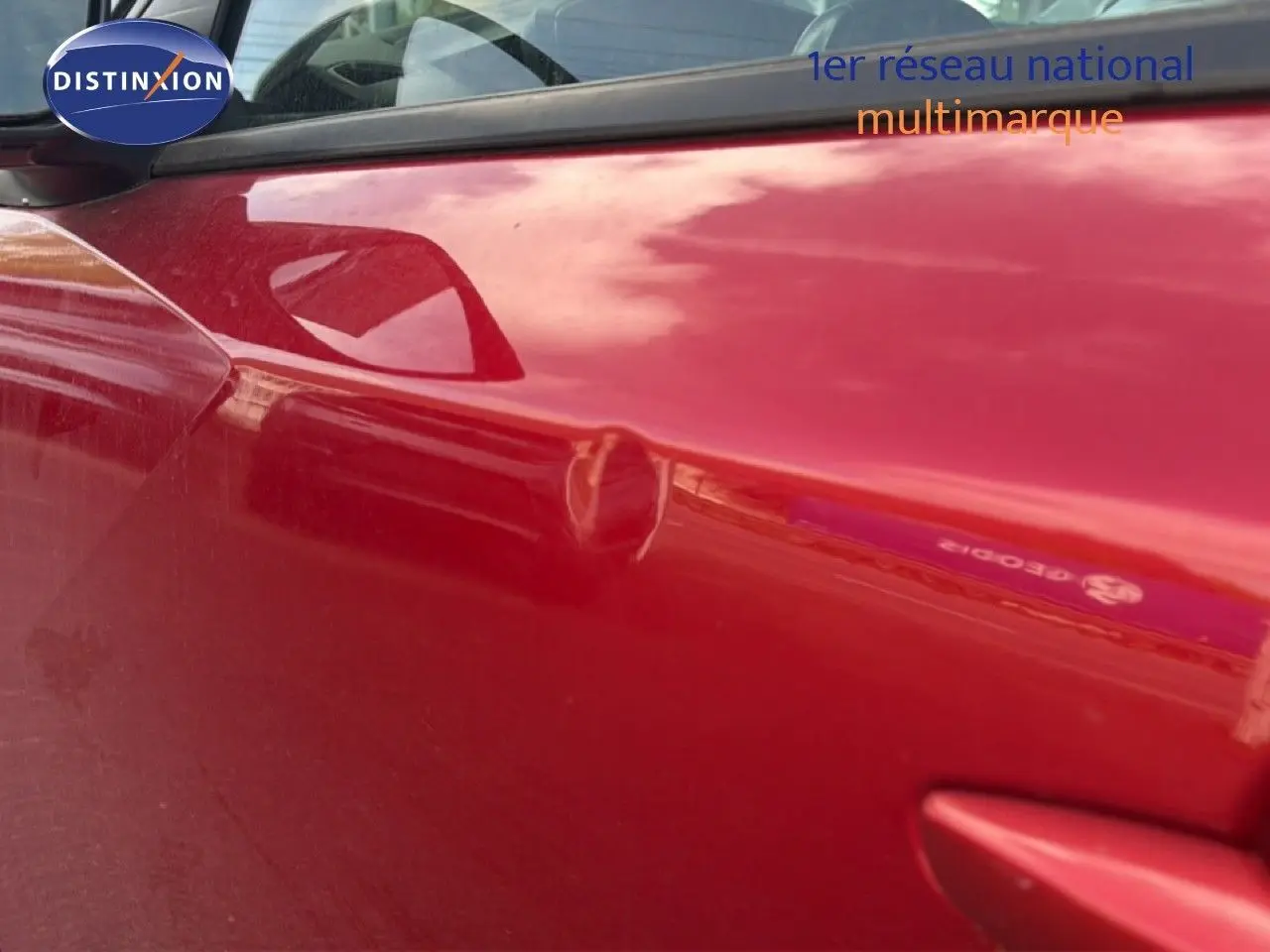 Gros plan sur la porte avant gauche rouge d’un Peugeot 2008 2020 avec toit noir, mettant en valeur la poignée et le rétroviseur.