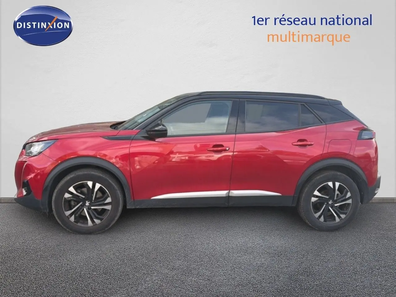 Peugeot 2008 rouge avec toit noir, vue de profil côté gauche sur fond neutre, jantes alliage bicolores.