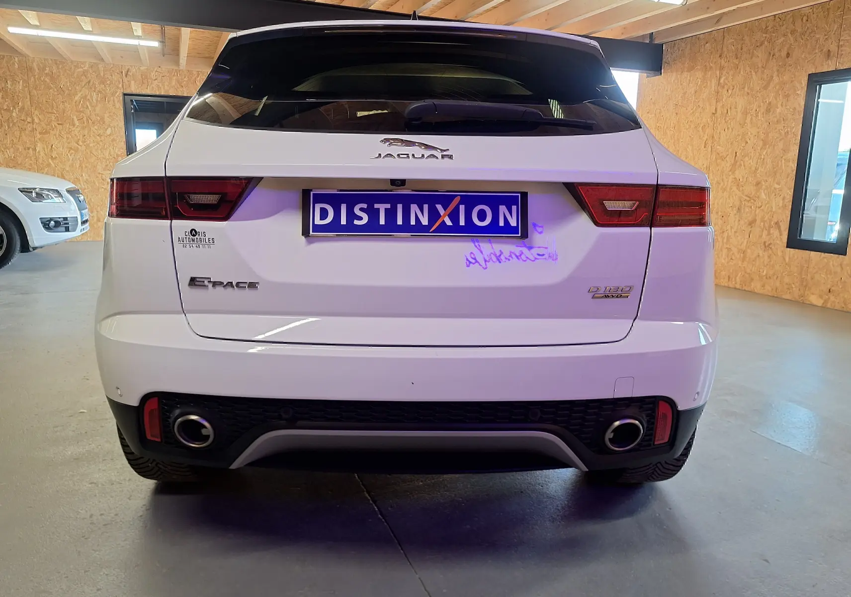 Vue arrière du Jaguar E-PACE blanc 2019 avec double sortie d'échappement et feux arrière LED en intérieur.