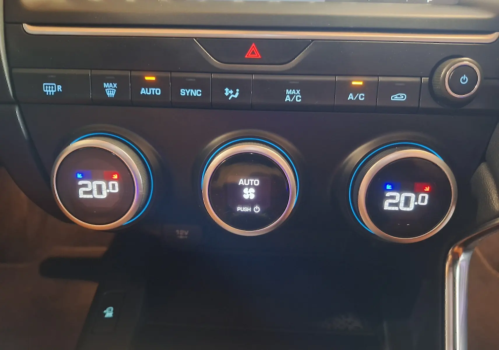 Gros plan sur les commandes de climatisation automatique du Jaguar E-PACE blanc, affichant 20°C des deux côtés.