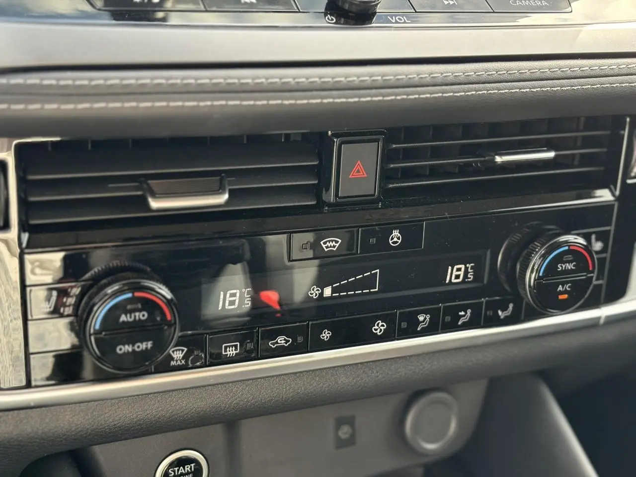 Détail de la console centrale noire du Nissan Qashqai 2025 avec climatisation automatique bi-zone et commandes tactiles.