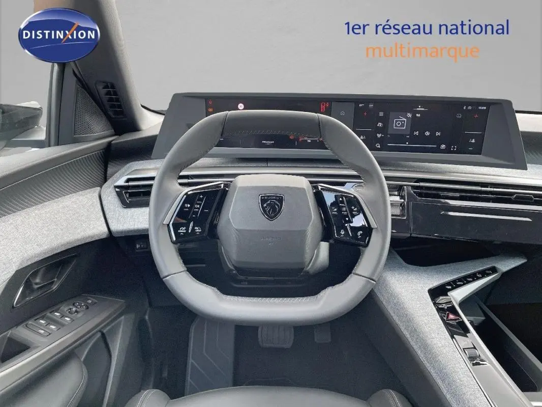 Vue intérieure centrée sur le volant cuir et le tableau de bord numérique du Peugeot 3008 hybride 2025.