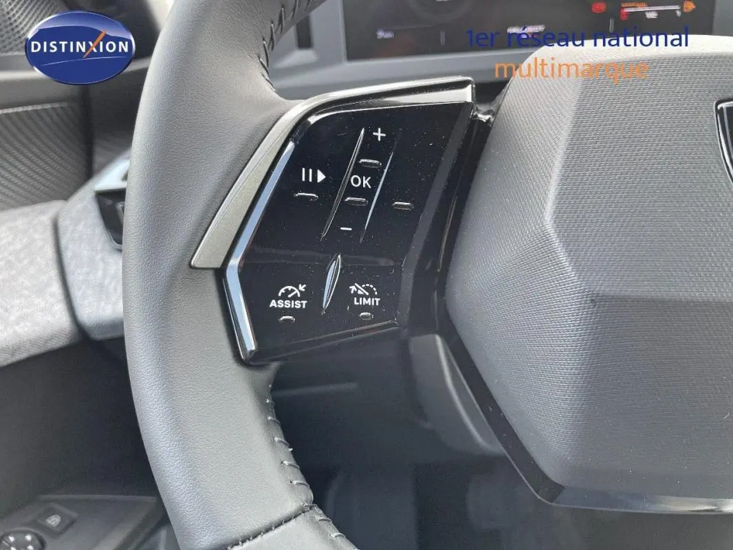 Gros plan sur les commandes au volant cuir du Peugeot 3008 bleu 2025, avec boutons d'assistance et limitation.