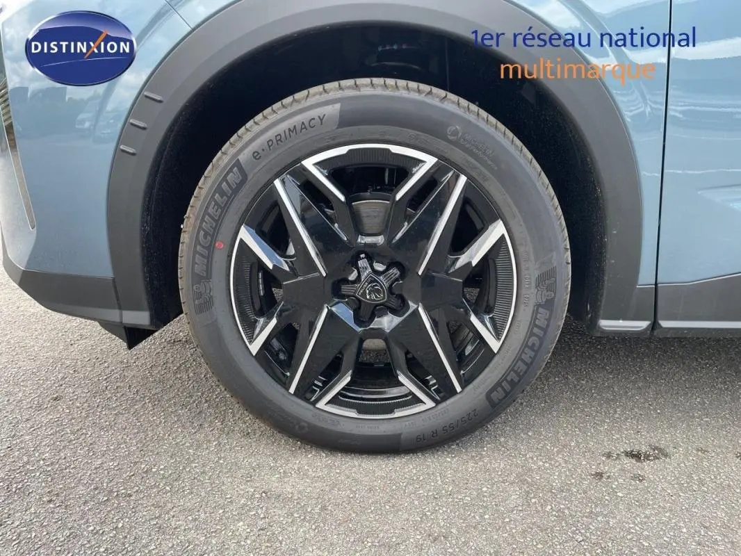 Gros plan sur la roue avant droite du Peugeot 3008 bleu 2025 avec jante aluminium noire et détails chromés.