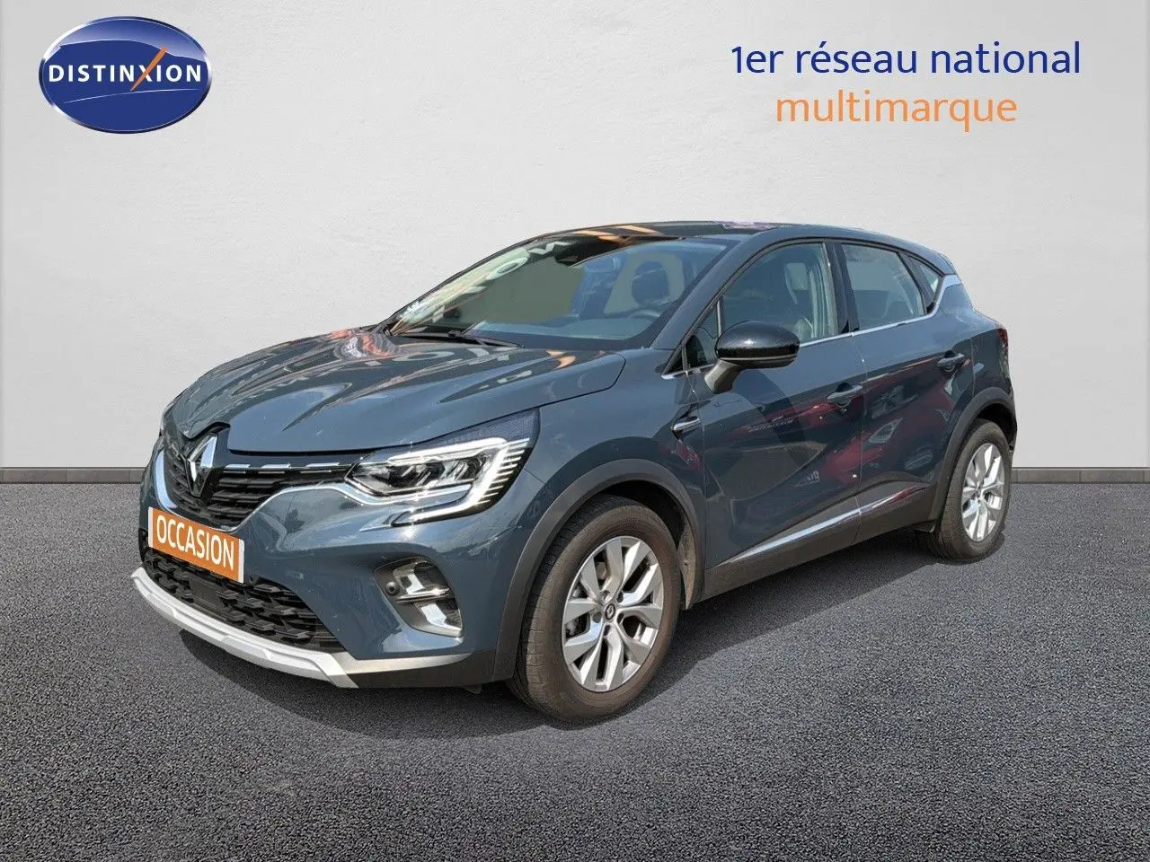 Renault Captur bleu marine fumé en 3/4 avant droit, avec jantes alliage et calandre distinctive 2022.