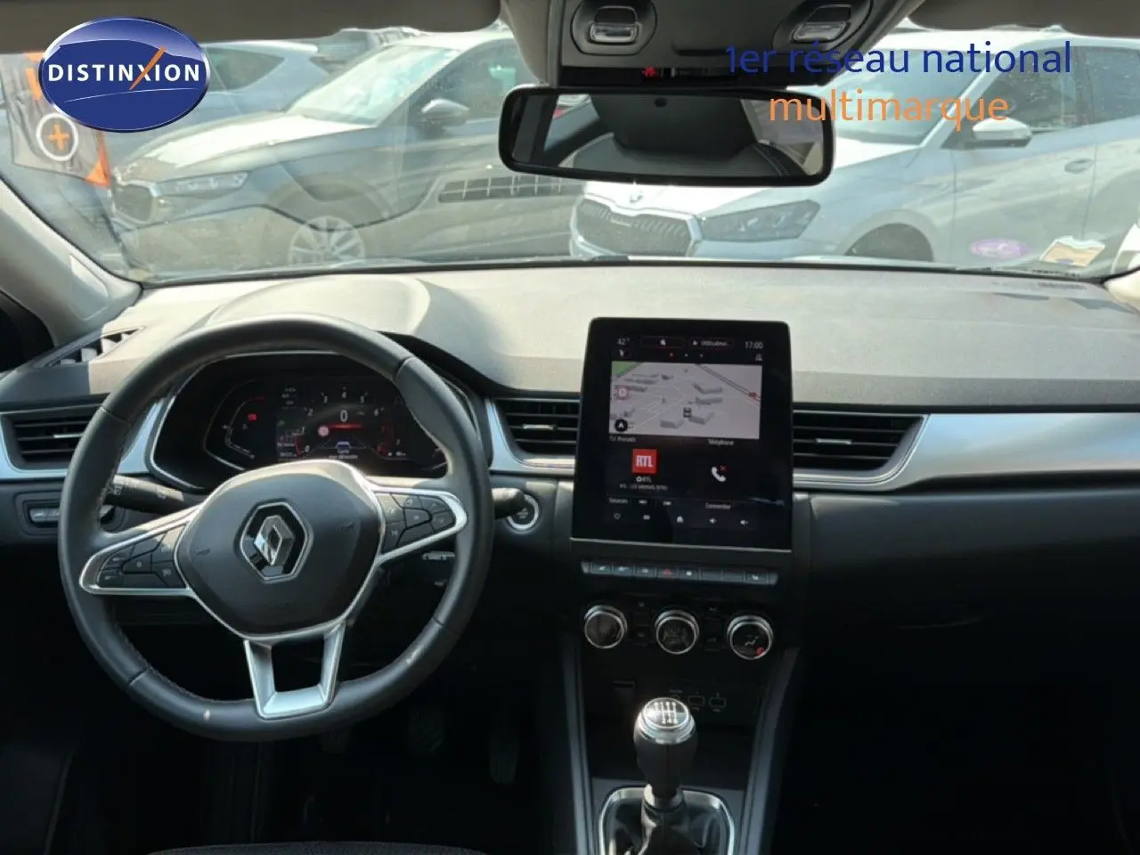 Vue intérieure du tableau de bord du Renault Captur bleu marine fumé 2022, avec volant multifonction et écran tactile central.
