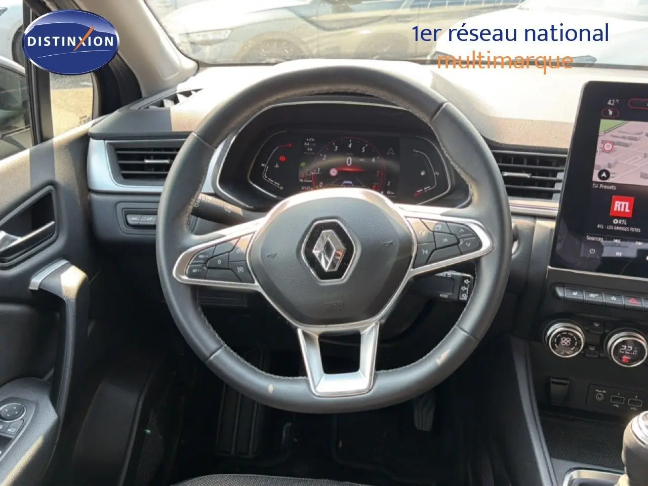 Vue intérieure centrée sur le volant du Renault Captur 1.3 TCe bleu marine fumé, avec tableau de bord numérique et écran tactile.