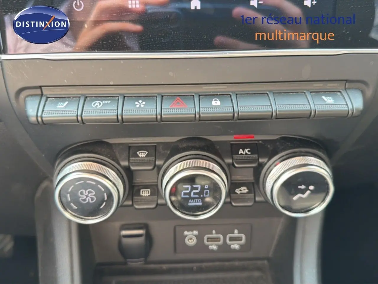 Gros plan sur la console centrale du Renault Captur 2022, montrant les commandes de climatisation et les boutons fonctionnels.